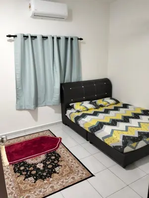 a bedroom with a bed and a rug at Arima Homestay A in Permatang Janggus