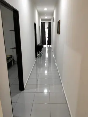 a hallway with white walls and a white tile floor at Arima Homestay A in Permatang Janggus