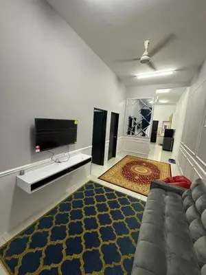 a living room with a couch and a flat screen tv at Homestay Warisan Taiping in Kampong Melayu Changkat Larah