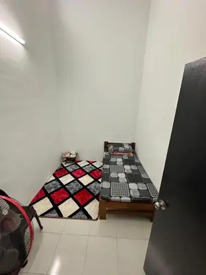 a small room with a bed and a quilt at Homestay Warisan Taiping in Kampong Melayu Changkat Larah