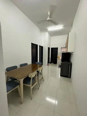 a dining room with a wooden table and chairs at Homestay Warisan Taiping in Kampong Melayu Changkat Larah