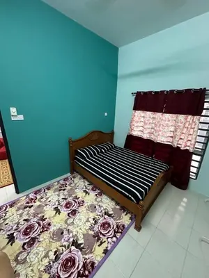 a bedroom with a bed with a floral comforter at Homestay Warisan Taiping in Kampong Melayu Changkat Larah