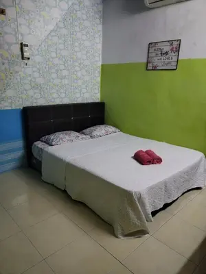 a bed in a room with a red hat on it at Seadanya Homestay Kamunting in Kampong Melayu Changkat Larah