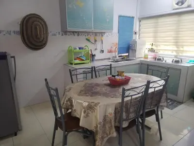 a kitchen with a table with chairs and a sink at Seadanya Homestay Kamunting in Kampong Melayu Changkat Larah