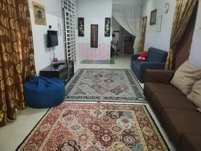 a living room with a couch and a rug at Seadanya Homestay Kamunting in Kampong Melayu Changkat Larah
