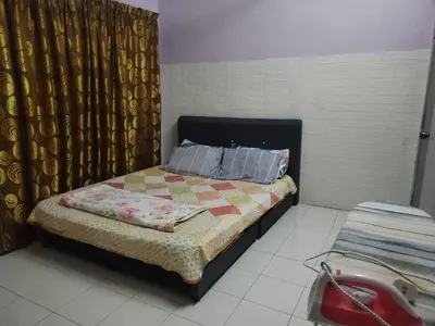 a bedroom with a bed with a quilt on it at Seadanya Homestay Kamunting in Kampong Melayu Changkat Larah