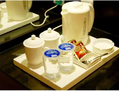 a tray with cups and a tea pot and glasses at ERNES Hotel Bandar Perda in Kampong Permatang Batu