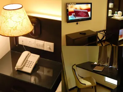 a hotel room with a phone and a desk at ERNES Hotel Bandar Perda in Kampong Permatang Batu