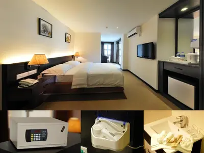 a hotel room with a bed and a sink at ERNES Hotel Bandar Perda in Kampong Permatang Batu