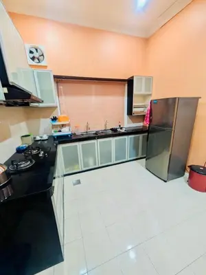 a kitchen with a refrigerator and a counter top at Seri Changkat Homestay in Kampong Changkat Raja