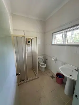 a bathroom with a shower and a toilet and a sink at Orchard Lake House - Entire bungalow, 4 rooms, 9 beds, 13 persons in Behrang Hulu