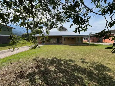 a house with a large yard in front of it at Orchard Lake House - Entire bungalow, 4 rooms, 9 beds, 13 persons in Behrang Hulu