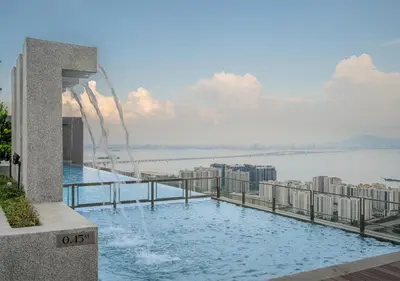 a swimming pool on top of a building with a water fountain at Iconic Regency Service Residences, managed by Iconic Hotel in Bayan Lepas