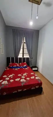 a bedroom with a bed with a red comforter and a window at Big Mama's House in Tanah Rata