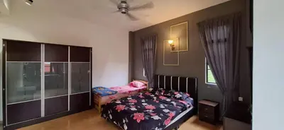 a bedroom with a bed and a dresser at Big Mama's House in Tanah Rata