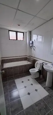 a bathroom with a tub and a toilet and a sink at Big Mama's House in Tanah Rata