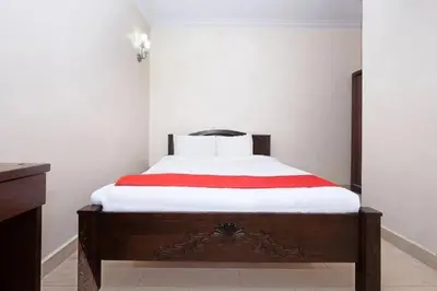 a bedroom with a bed with a red and white blanket at Lumut Villa Inn in Kampong Tebing Rabak
