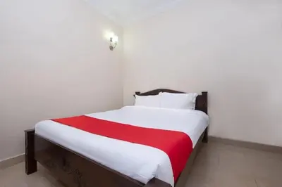 a bedroom with a bed with a red and white blanket at Lumut Villa Inn in Kampong Tebing Rabak