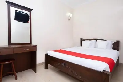 a bedroom with a bed and a dresser and a mirror at Lumut Villa Inn in Kampong Tebing Rabak
