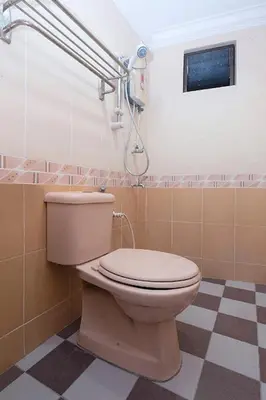 a bathroom with a toilet and a shower at Lumut Villa Inn in Kampong Tebing Rabak