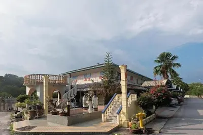 a large building with a staircase and a balcony at Lumut Villa Inn in Kampong Tebing Rabak