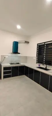 a white kitchen with a counter with a computer on it at Homestay Bandar Puteri Jaya in Sungai Petani