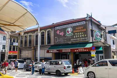 a busy city street with cars parked in front of a building at De Quinton Hotel in Ipoh