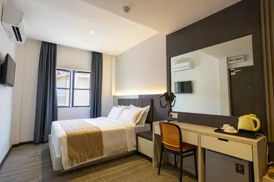 a hotel room with a bed and a desk at De Quinton Hotel in Ipoh