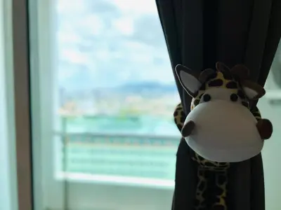 a stuffed giraffe toy hanging from a window at Mansion One l 4pax Studio l MountainView & CityView l Gleneagles l by PerfectSweetHome in George Town