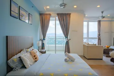 a bedroom with a large bed and a living room at Mansion One l 4pax Studio l MountainView & CityView l Gleneagles l by PerfectSweetHome in George Town