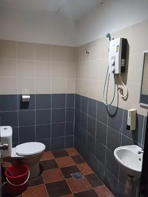 a bathroom with a toilet and a sink at Hotel Kavanass Inn in Simpang