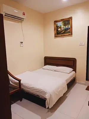 a bedroom with a bed and a air conditioner at Hotel Kavanass Inn in Simpang