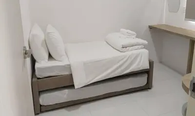 a white room with a bed and a chair at IFS Seri Iskandar by Glex in Seri Iskandar