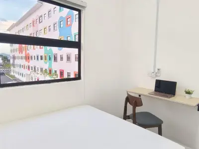 a bedroom with a bed and a desk and a window at IFS Seri Iskandar by Glex in Seri Iskandar