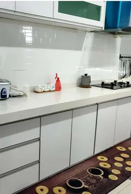 a kitchen with white cabinets and a counter top at Harmoni Citra Guesthouse Bertam in Kampong Sungai Korok