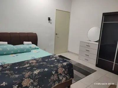 a bedroom with a bed and a flat screen tv at Harmoni Citra Guesthouse Bertam in Kampong Sungai Korok