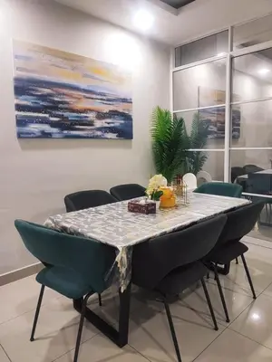 a dining room table with chairs and a painting at Harmoni Citra Guesthouse Bertam in Kampong Sungai Korok