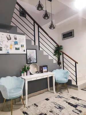 a room with a table and two chairs and a staircase at Harmoni Citra Guesthouse Bertam in Kampong Sungai Korok