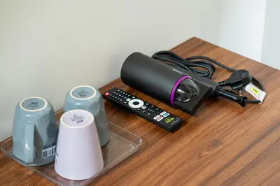 a table with a remote control and other electronic devices at Jovial Industrial Stylish Lodge ````Bukit Mertajam in Bukit Mertajam