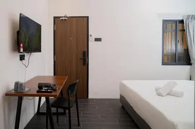 a hotel room with a bed and a table and a desk at Jovial Industrial Stylish Lodge ````Bukit Mertajam in Bukit Mertajam