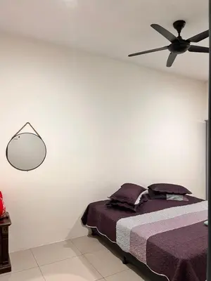 a bedroom with a bed with a ceiling fan at Homestay Ummi Seri Iskandar in Seri Iskandar