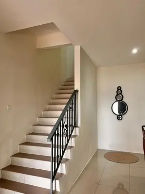 a staircase in a house with a black railing at Homestay Ummi Seri Iskandar in Seri Iskandar