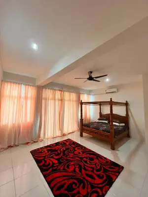 a bedroom with a bed and a rug on the floor at Homestay Ummi Seri Iskandar in Seri Iskandar