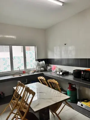 a kitchen with a table and chairs in it at Homestay Ummi Seri Iskandar in Seri Iskandar