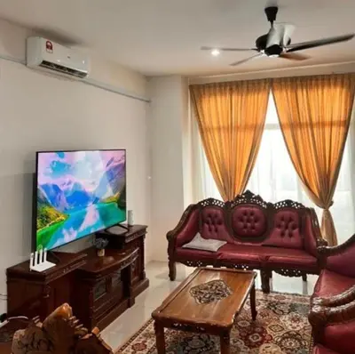 a living room with a couch and a flat screen tv at Homestay Ummi Seri Iskandar in Seri Iskandar