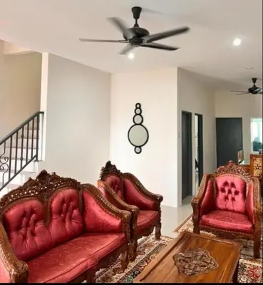 a living room with two red couches and a ceiling fan at Homestay Ummi Seri Iskandar in Seri Iskandar
