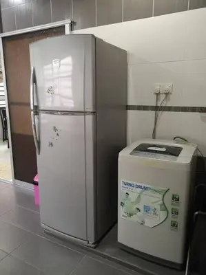 a refrigerator and a trash can in a room at \u4f18\u96c5\u805a\u6c11\u5bbfHome Stay in Kampong Kuala Punti
