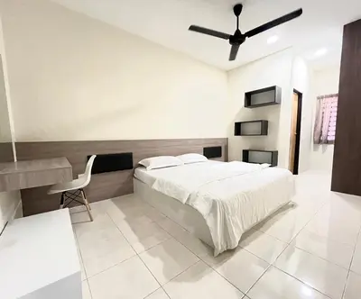 a white bedroom with a bed and a desk at AbelHome in Teluk Intan
