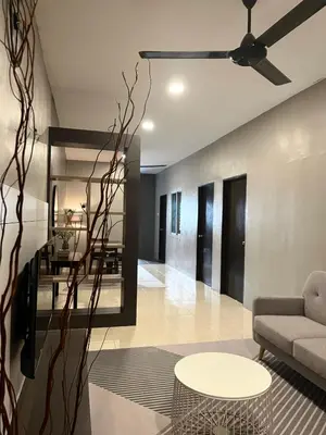 a living room with a ceiling fan and a table at AbelHome in Teluk Intan