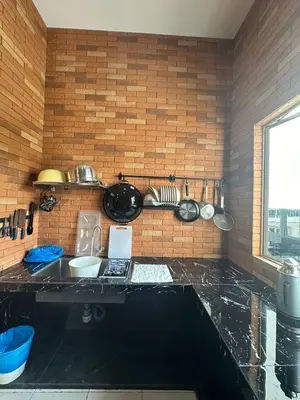 a kitchen with a black counter top in a room at Adik aisyah Cameron Black Pink in Tanah Rata